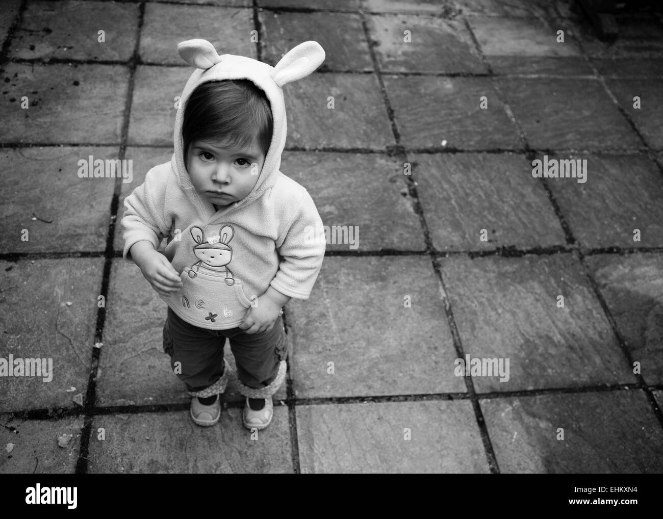 Little girl looking sad in hooded top with bunny ears Stock Photo