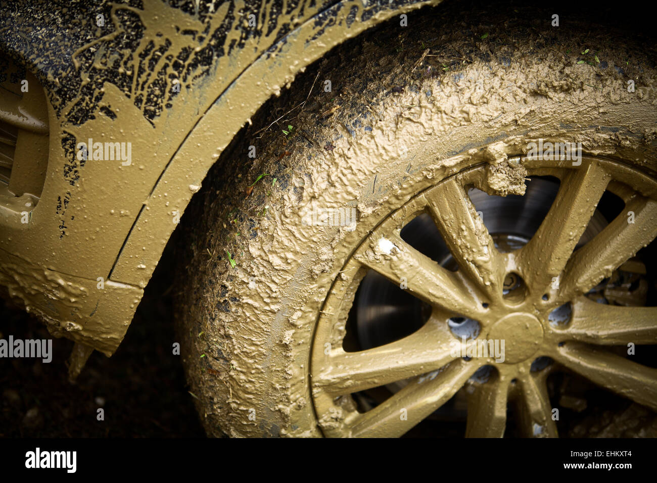 Color detail shot of an offroad car's wheel, covered in mud Stock