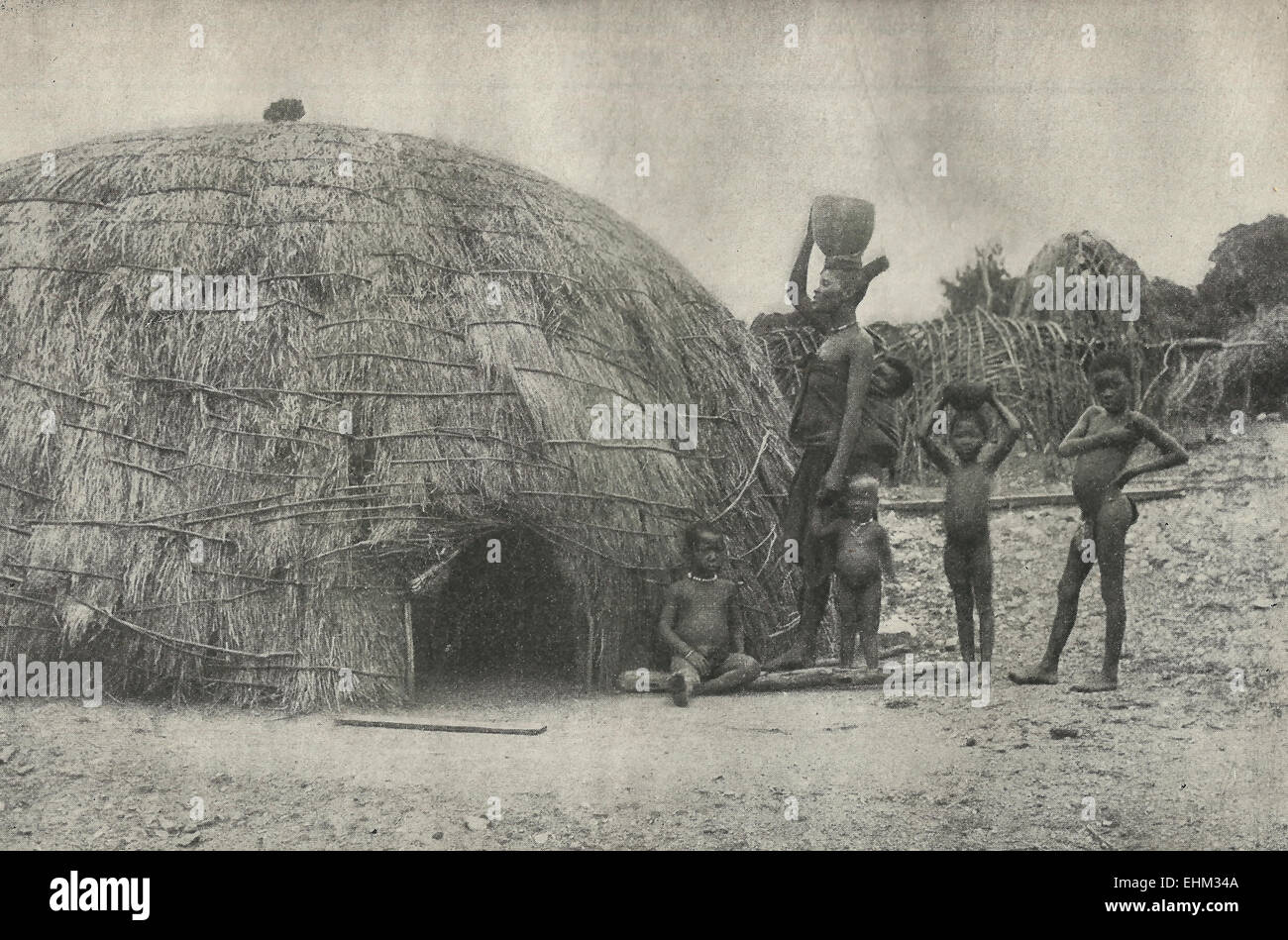 A Zulu hut with a family group, circa 1898 Stock Photo