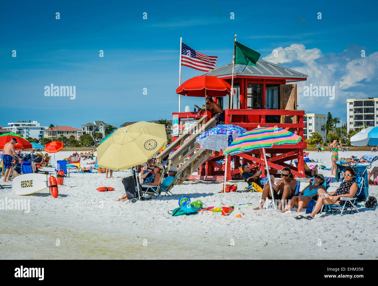 A life guard keeps watch at his Siesta Key Beach station while beach goers enjoy the warm and cloudy day in Sarasota, Florida Stock Photo