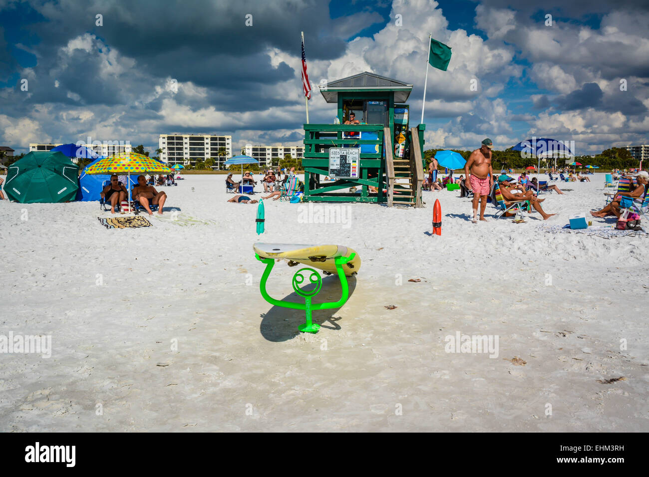 A life guard keeps watch at his Siesta Key Beach station while beach goers enjoy the warm and cloudy day in Sarasota, Florida Stock Photo