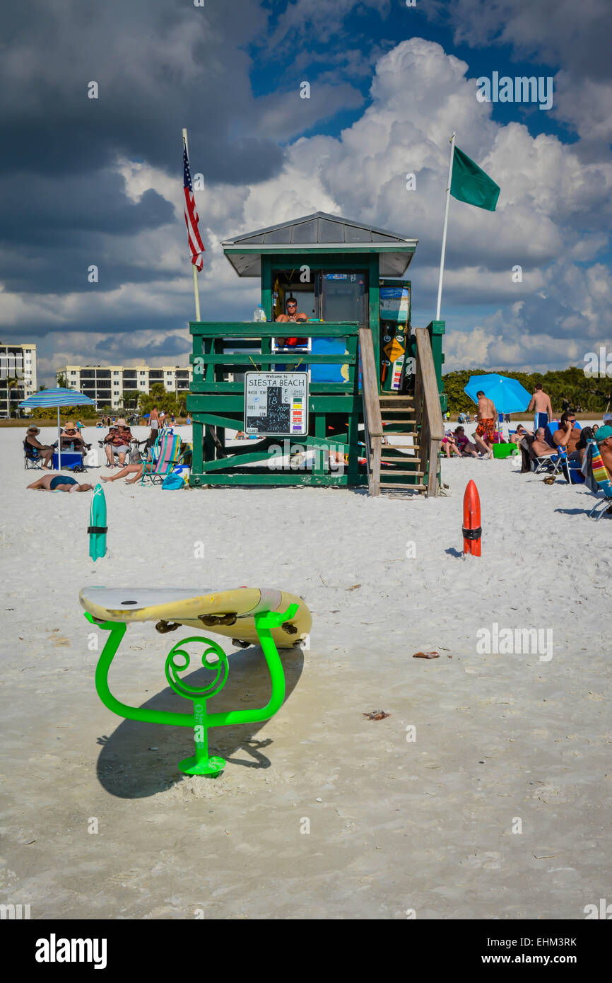 A life guard keeps watch at his Siesta Key Beach station while beach goers enjoy the warm and cloudy day in Sarasota, Florida Stock Photo