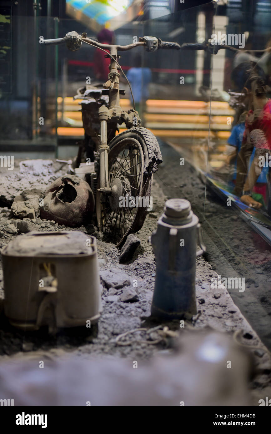 Bandung, Indonesia. 15th Mar, 2015. Children observe a damaged motorcycle hit by pyroclastic flows, at Geology Museum, Bandung, Indonesia. The artifact was taken from 2010 Mount Merapi eruption site in Yogyakarta province. Stock Photo