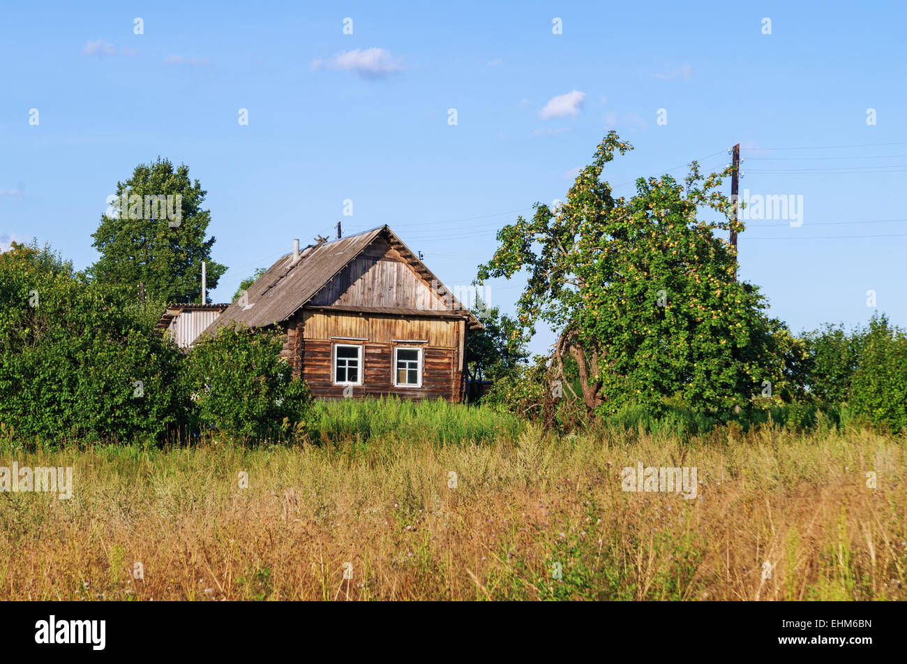 Summer day rural landscape with wooden house Stock Photo - Alamy