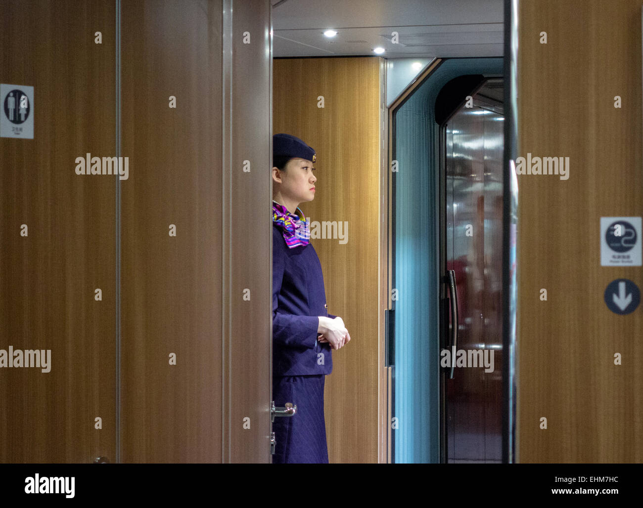 CRH steward standing in the passageway to welcome passengers Stock Photo