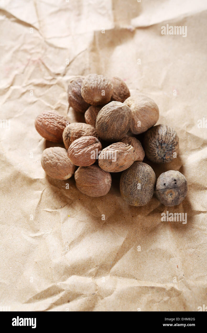 Nuts, nutmeg on the paper, spices Stock Photo Alamy