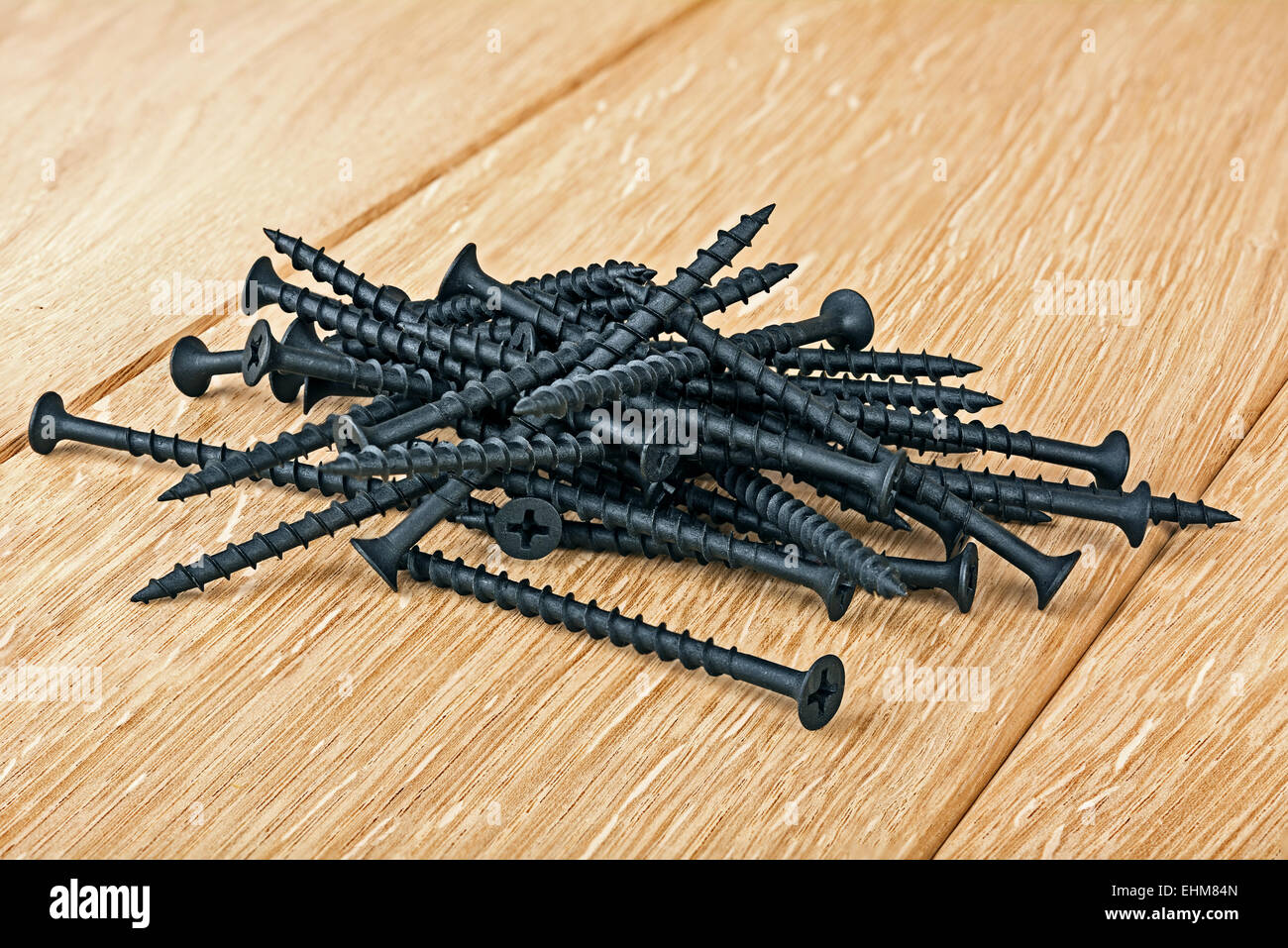 black screws for fixation of woods on wooden board . Most dust is destroyed, the area of focus is taken from six pictures Stock Photo
