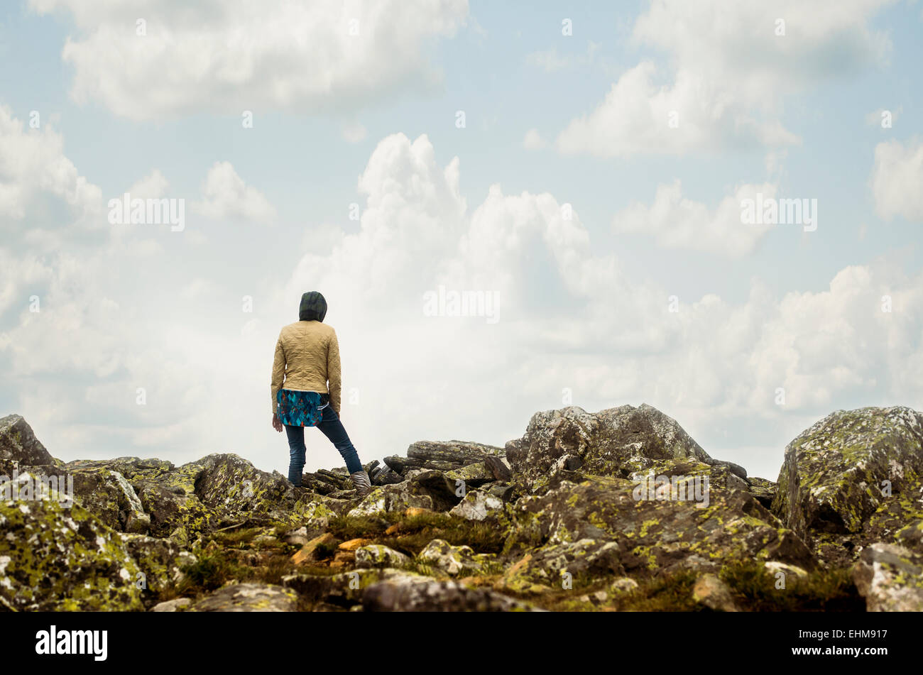 Caucasian hiker standing on rocky hilltop Stock Photo