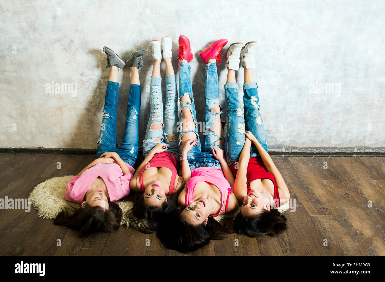Caucasian women laying on floor with feet on wall Stock Photo