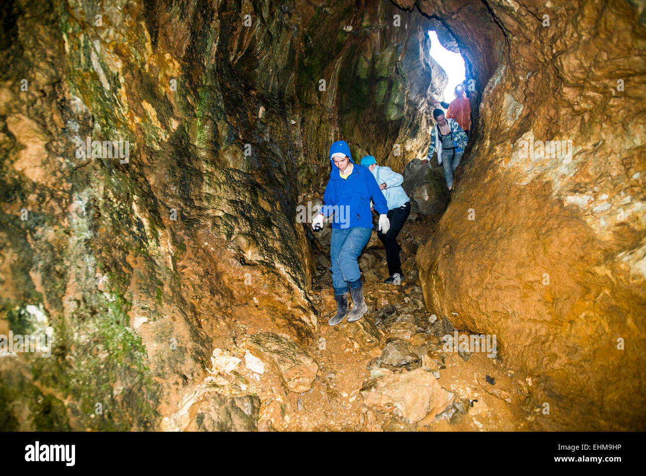 Caucasian people exploring rock formation cave Stock Photo
