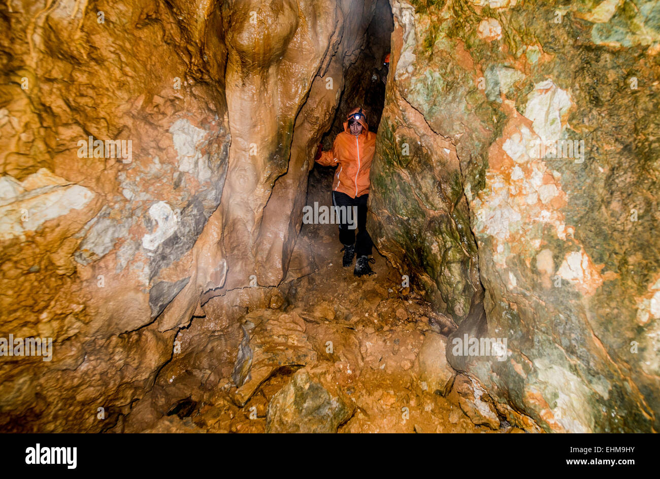 Caucasian woman exploring rock formation cave Stock Photo
