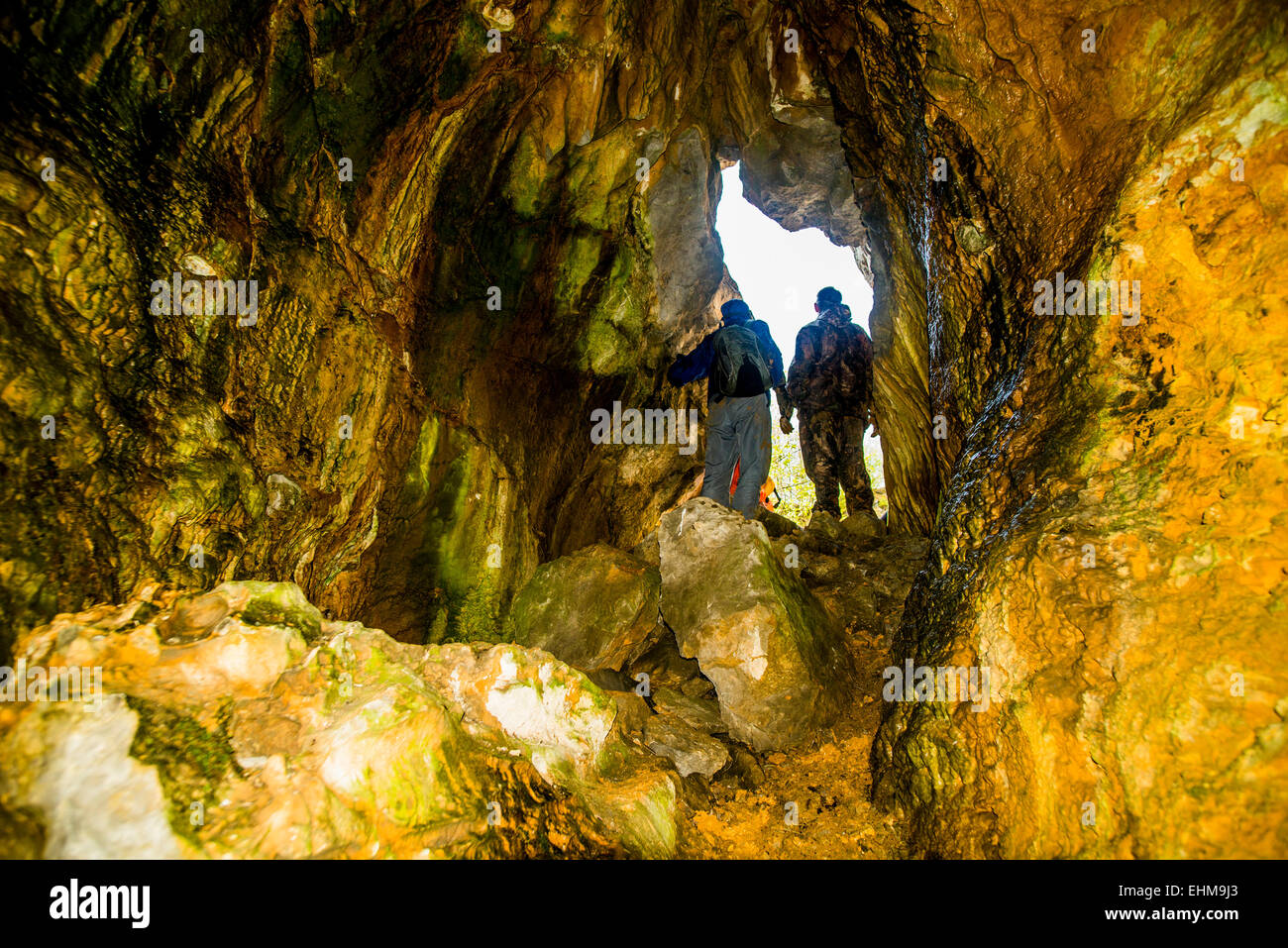 Caucasian men exploring rock formation cave Stock Photo