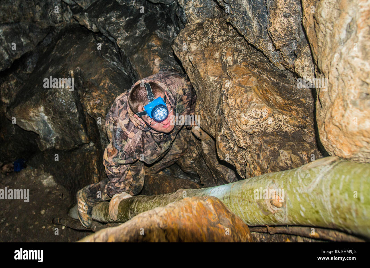 Caucasian climber exploring rock formation cave Stock Photo