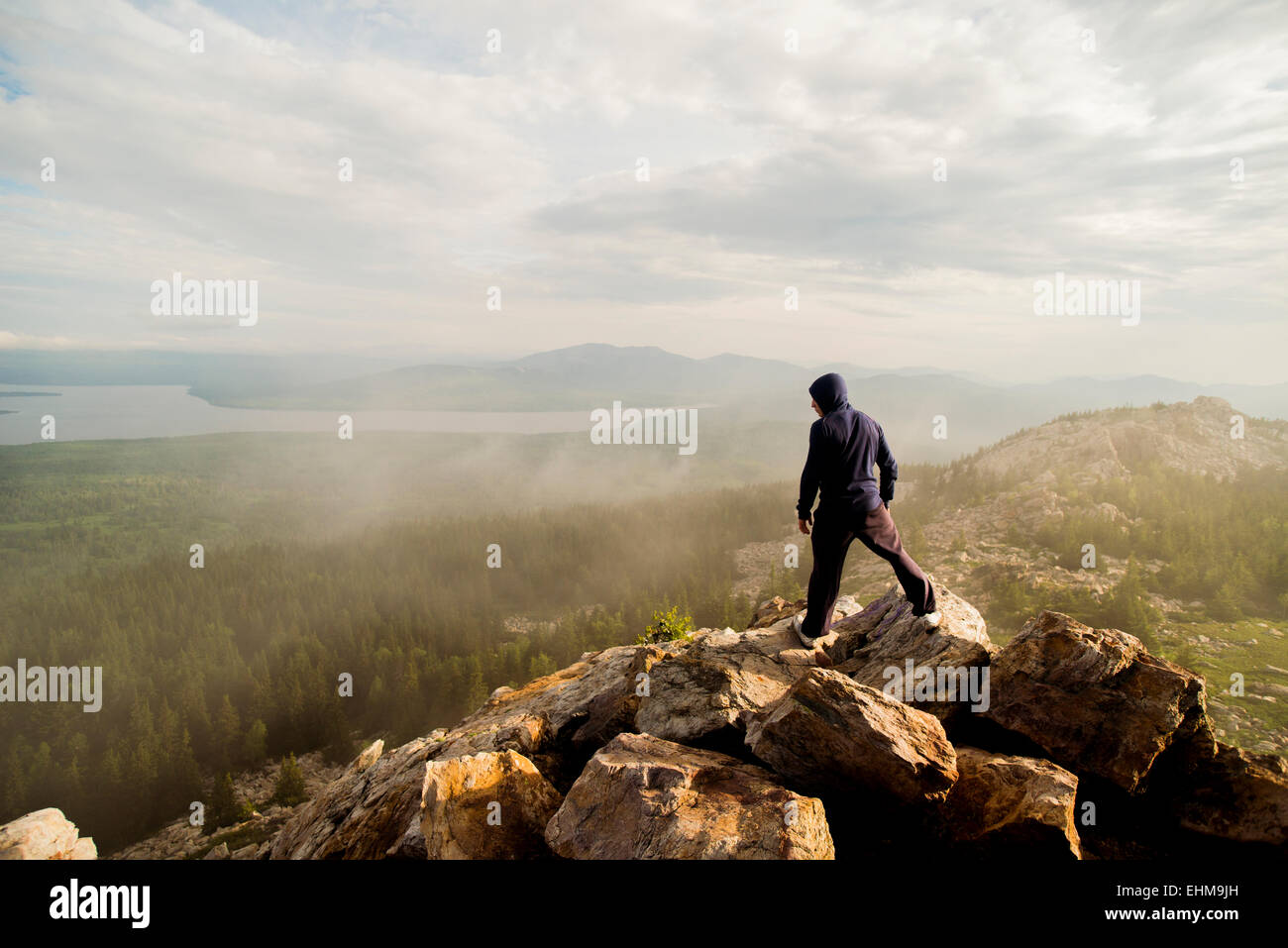 Caucasian hiker standing on rocky hilltop Stock Photo