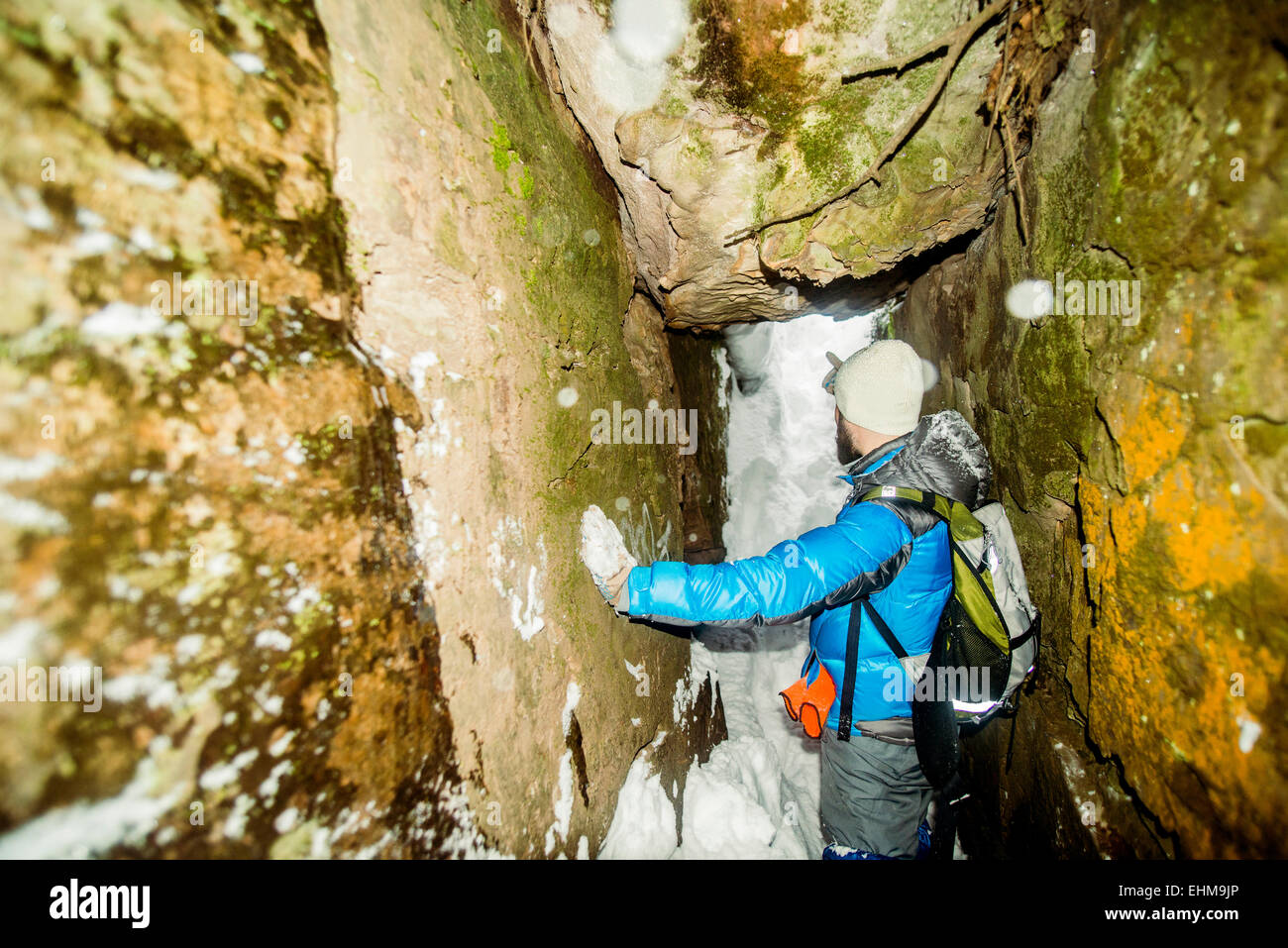 Caucasian hiker standing in snowy cave Stock Photo