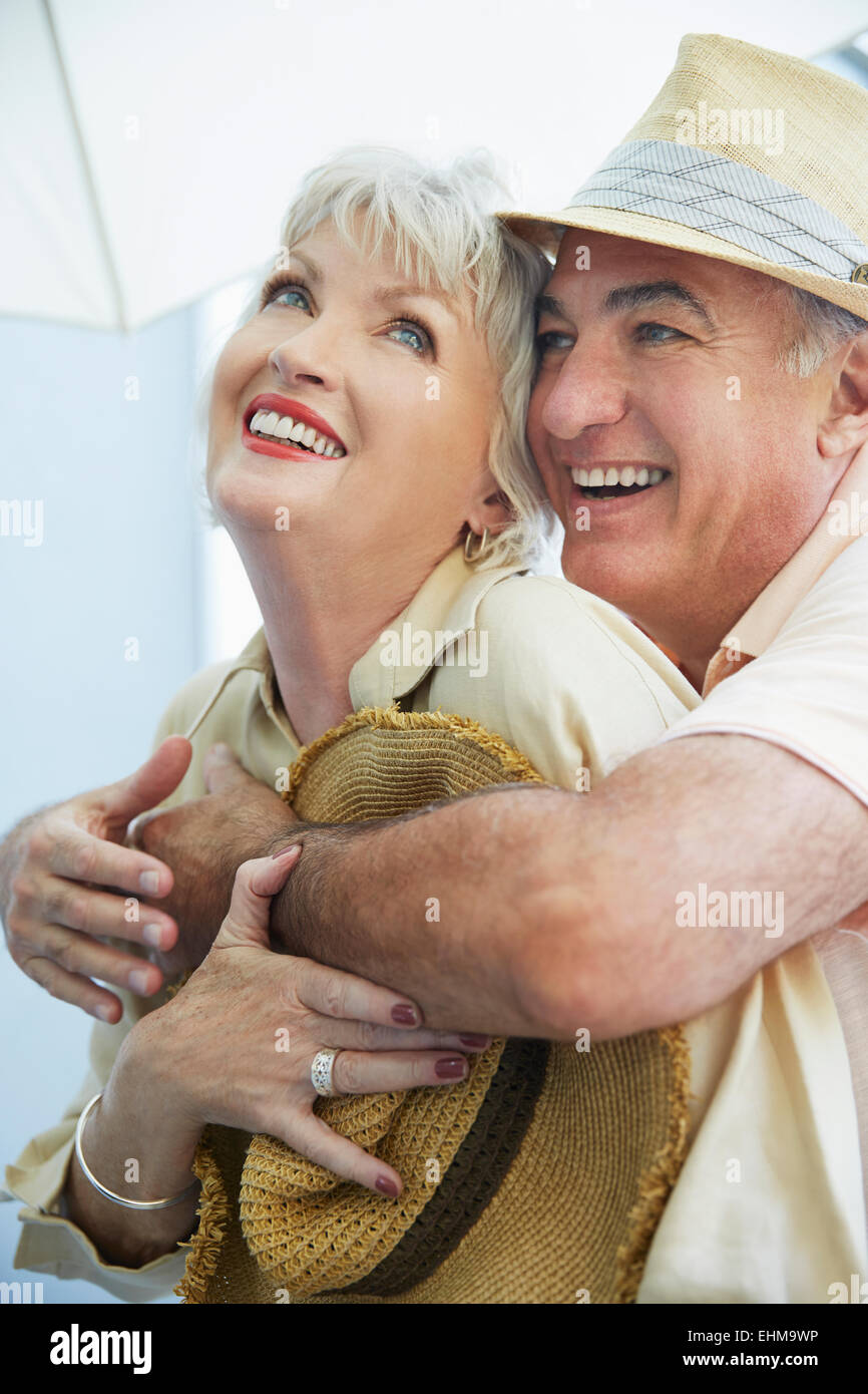 Older couple hugging outdoors Stock Photo