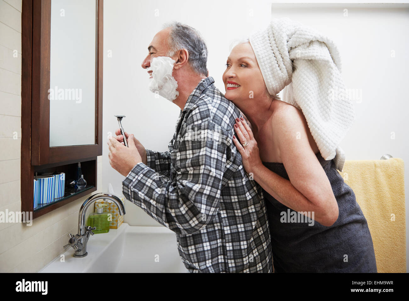 Older couple getting ready in bathroom Stock Photo