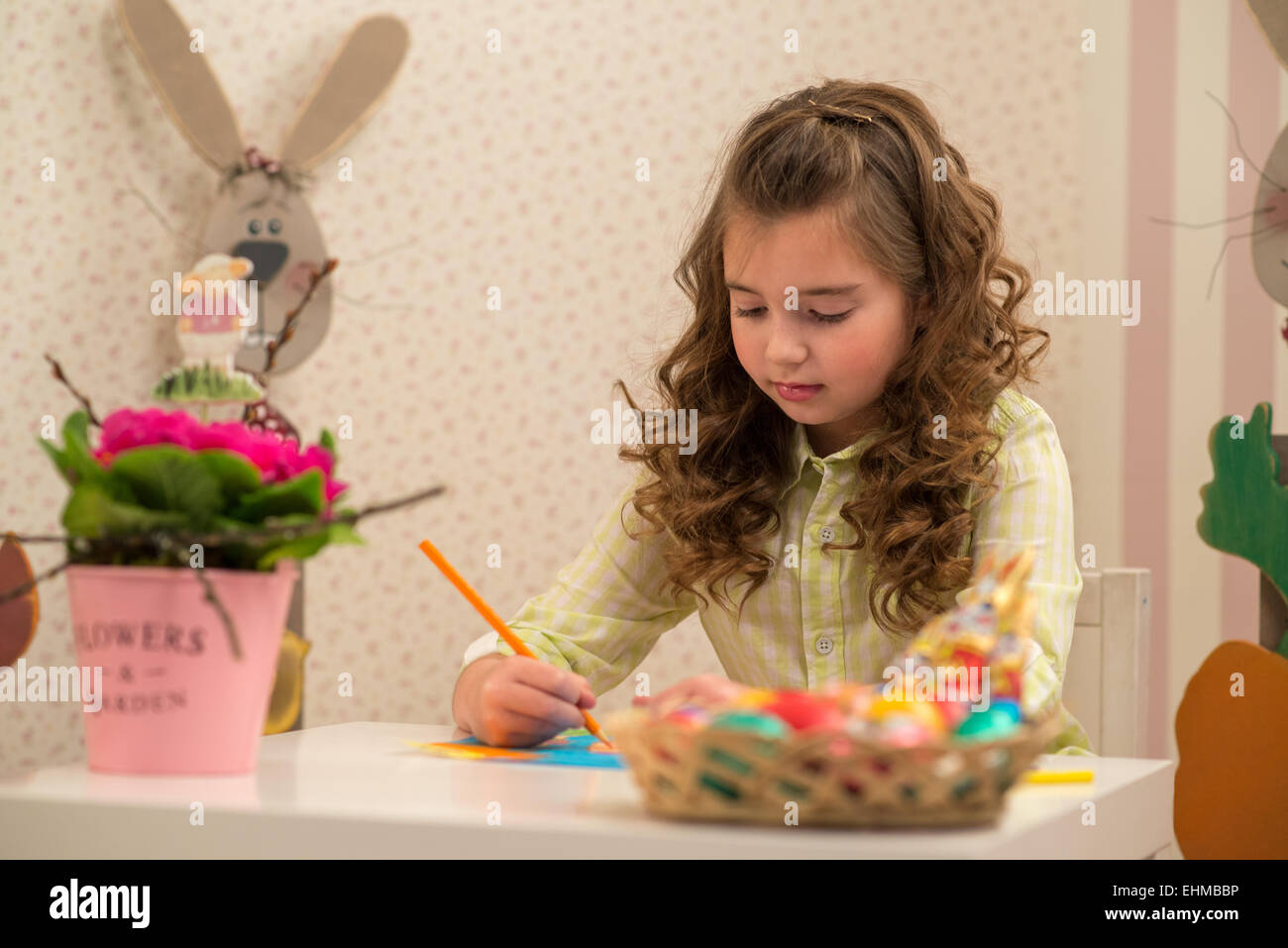 Little girl preparing for Easter - painting, drawing colored in the Room Stock Photo