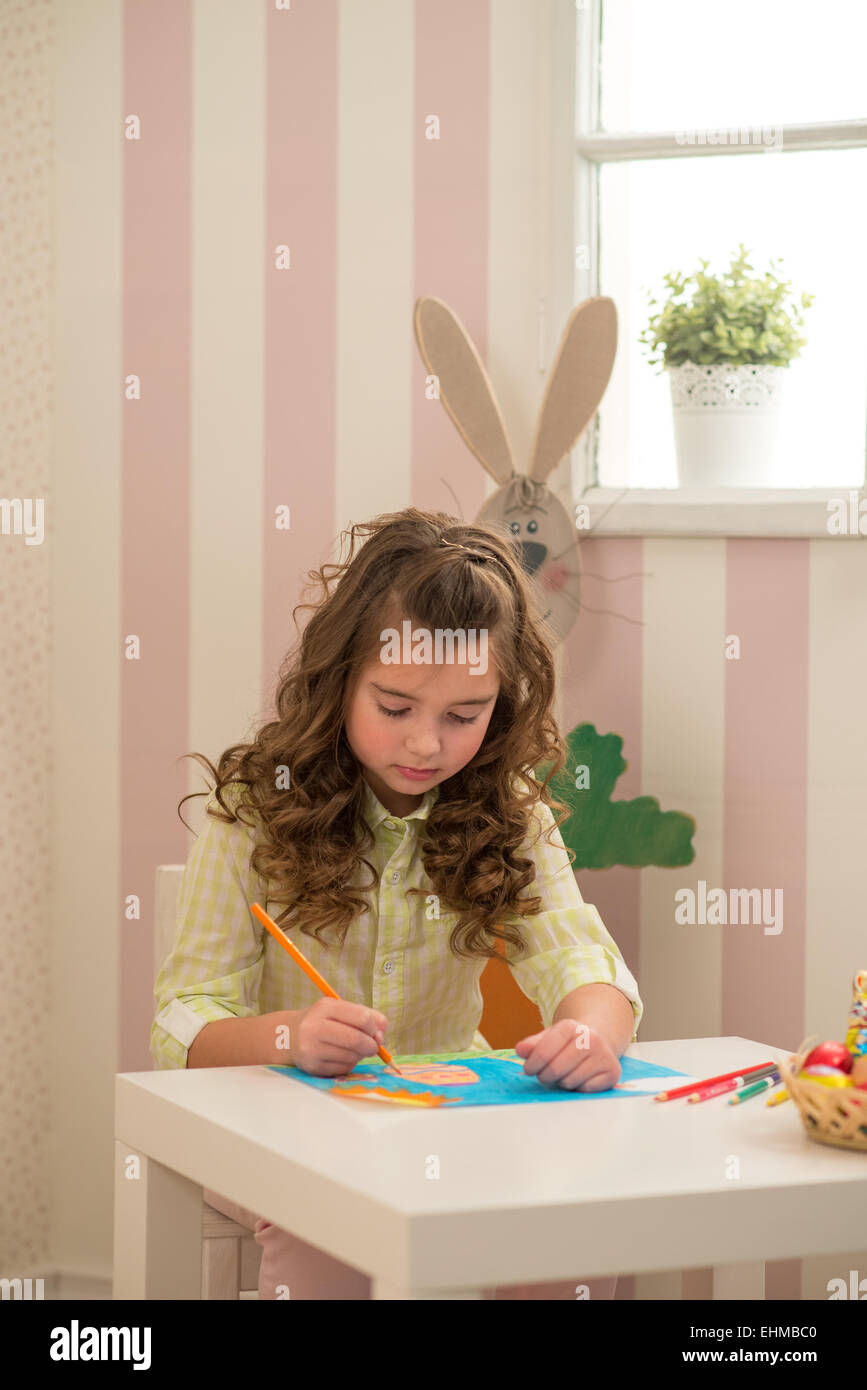 Little girl preparing for Easter - painting, drawing colored in the Room Stock Photo