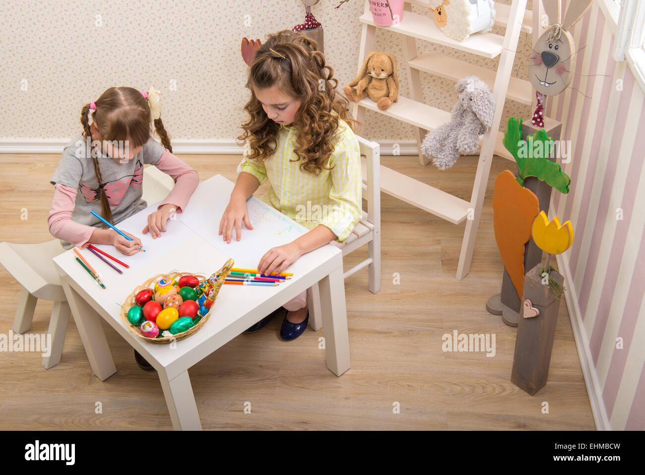 Little girls are made of Easter - they paint, they draw in the Room Stock Photo