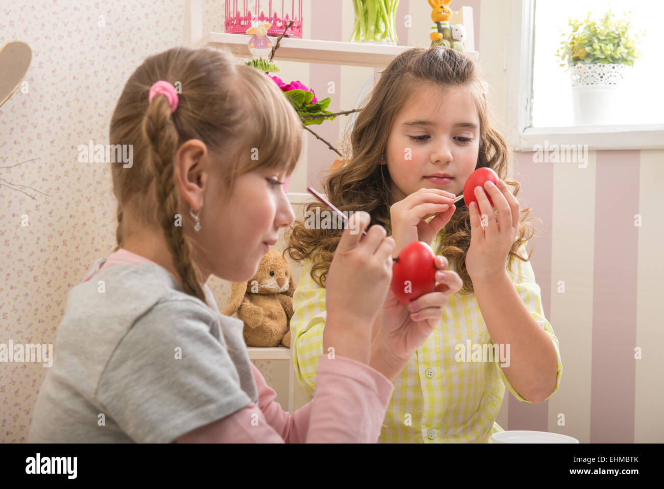 Little girls are made of Easter - they paint, they draw in the Room Stock Photo
