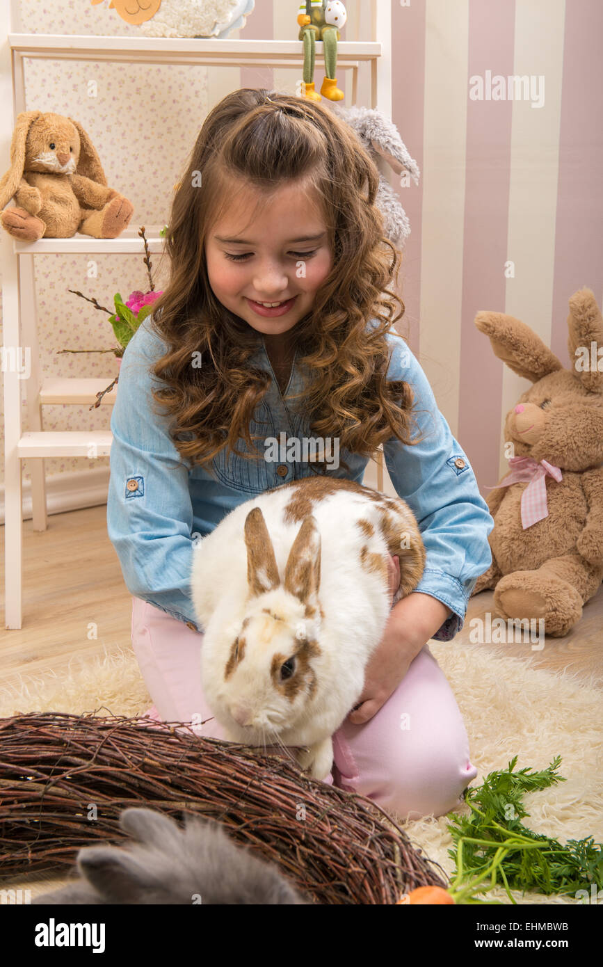 Easter - Little girls stroking the rabbits, the nest Stock Photo