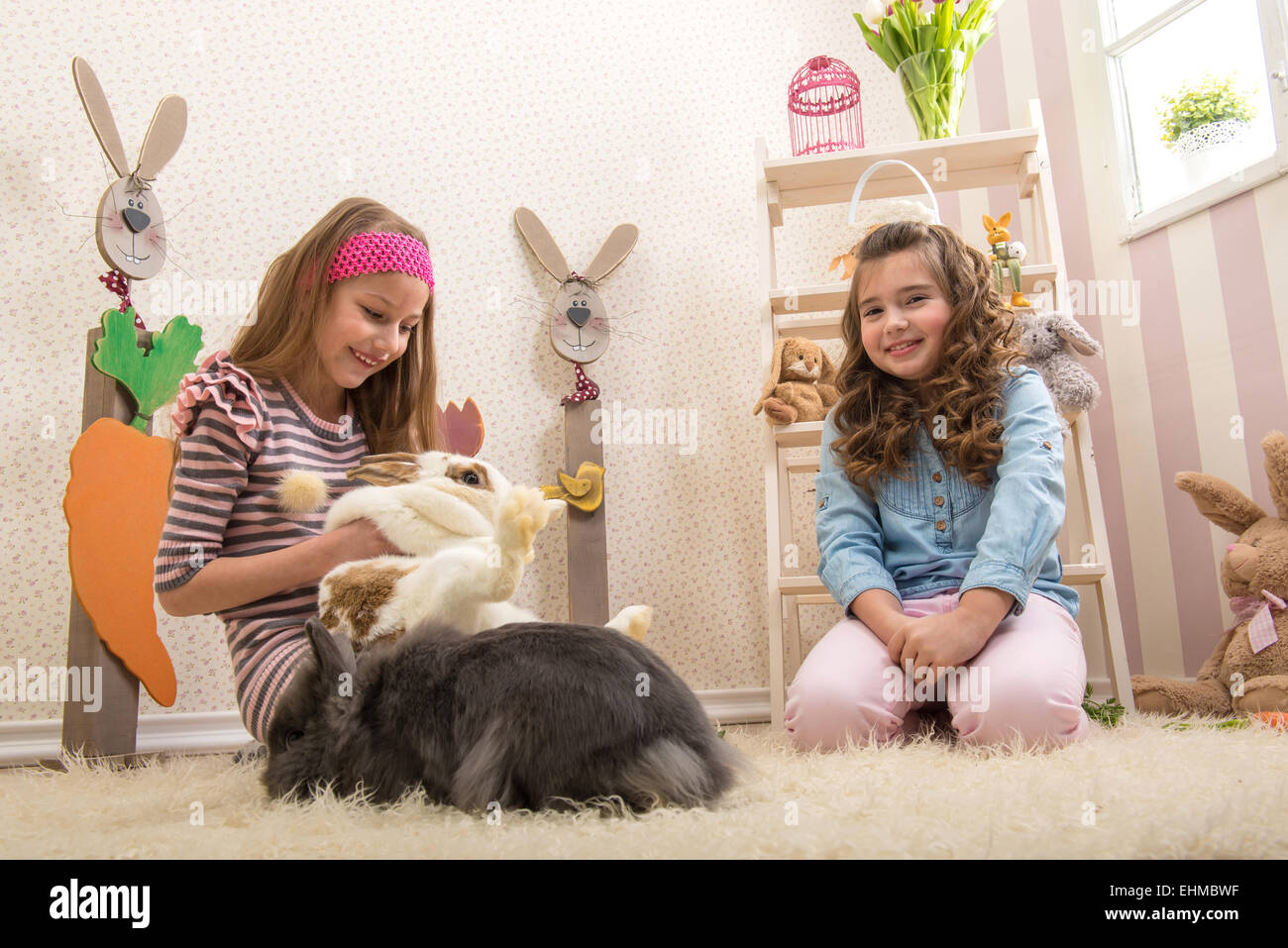 Easter - Little girls stroking the rabbits, hand beets Stock Photo