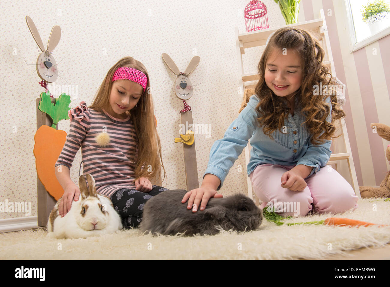 Easter - Little girls stroking the rabbits, hand beets Stock Photo