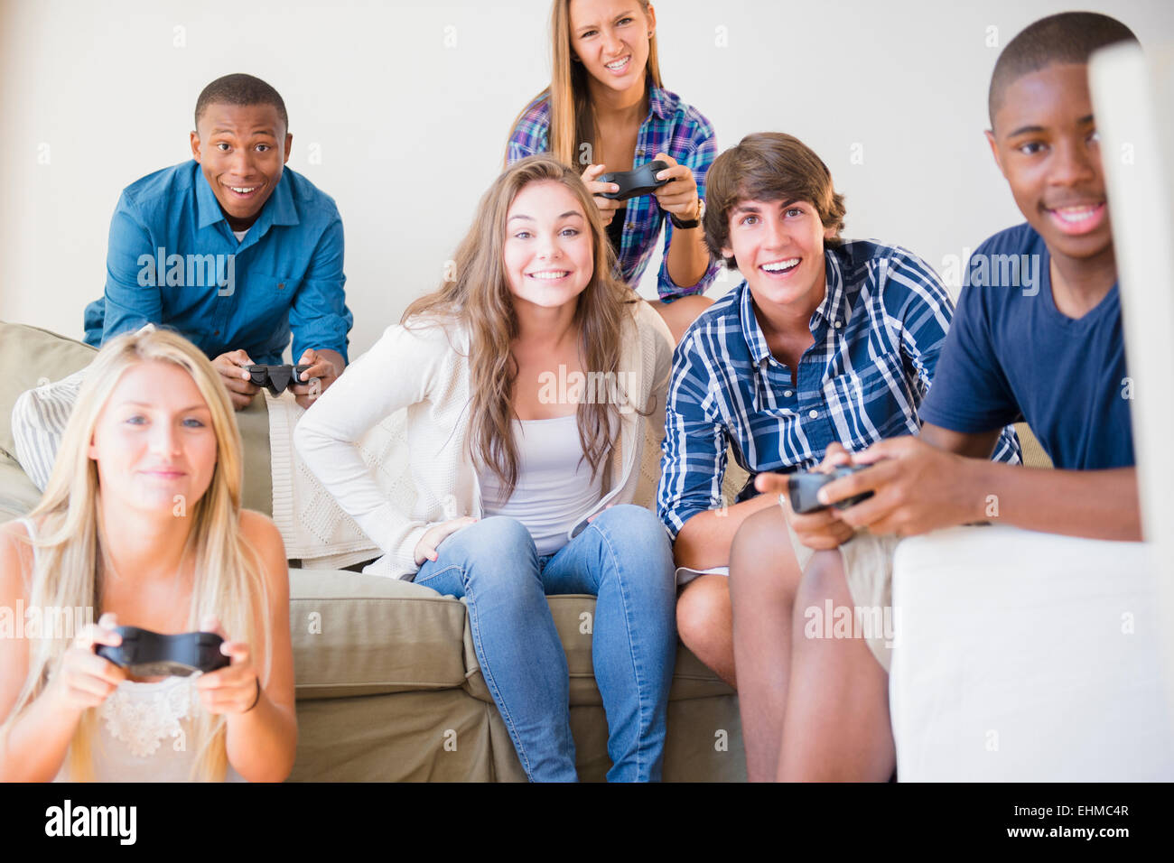 Teenagers playing video games in living room Stock Photo