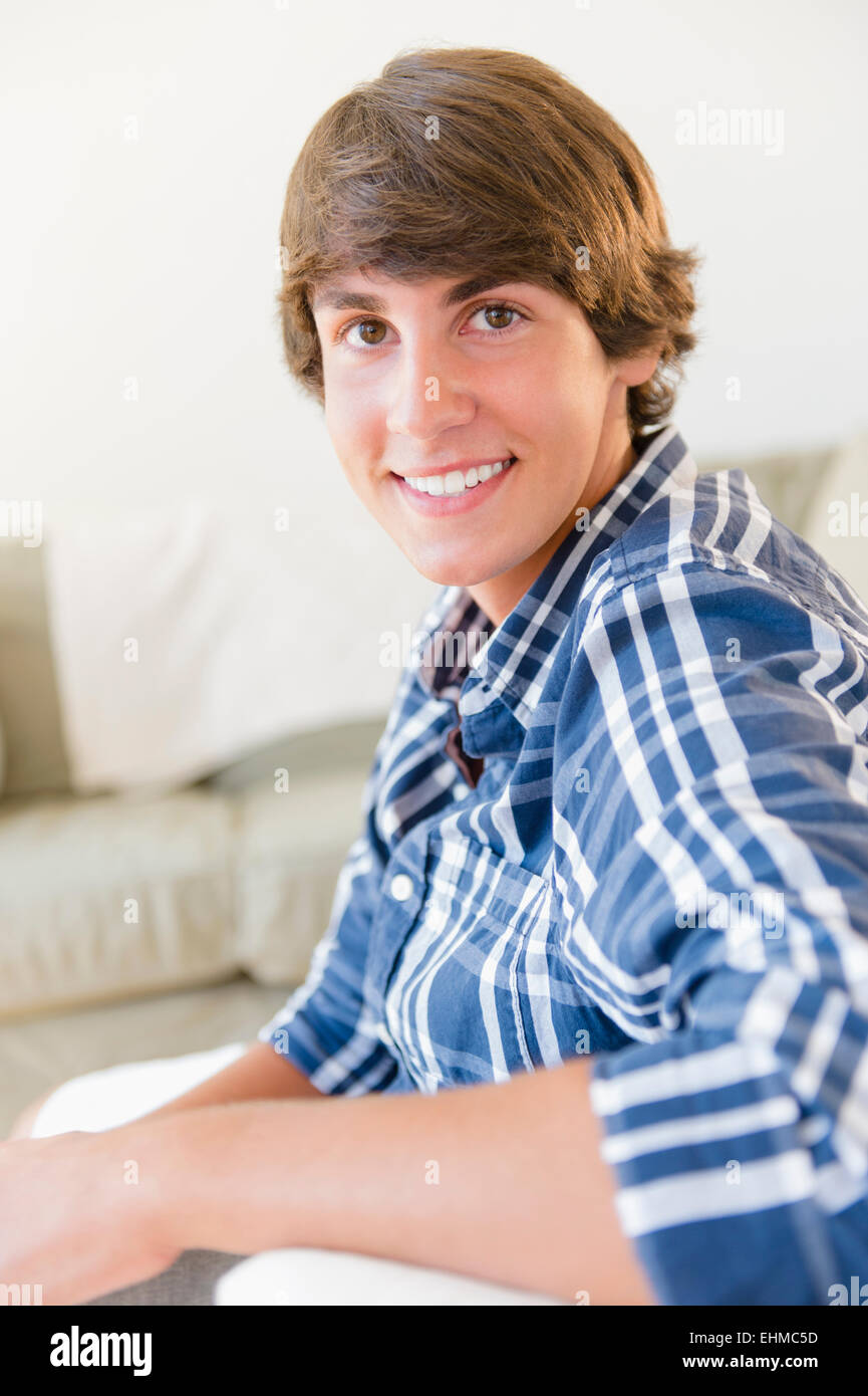 Caucasian teenage boy smiling in living room Stock Photo