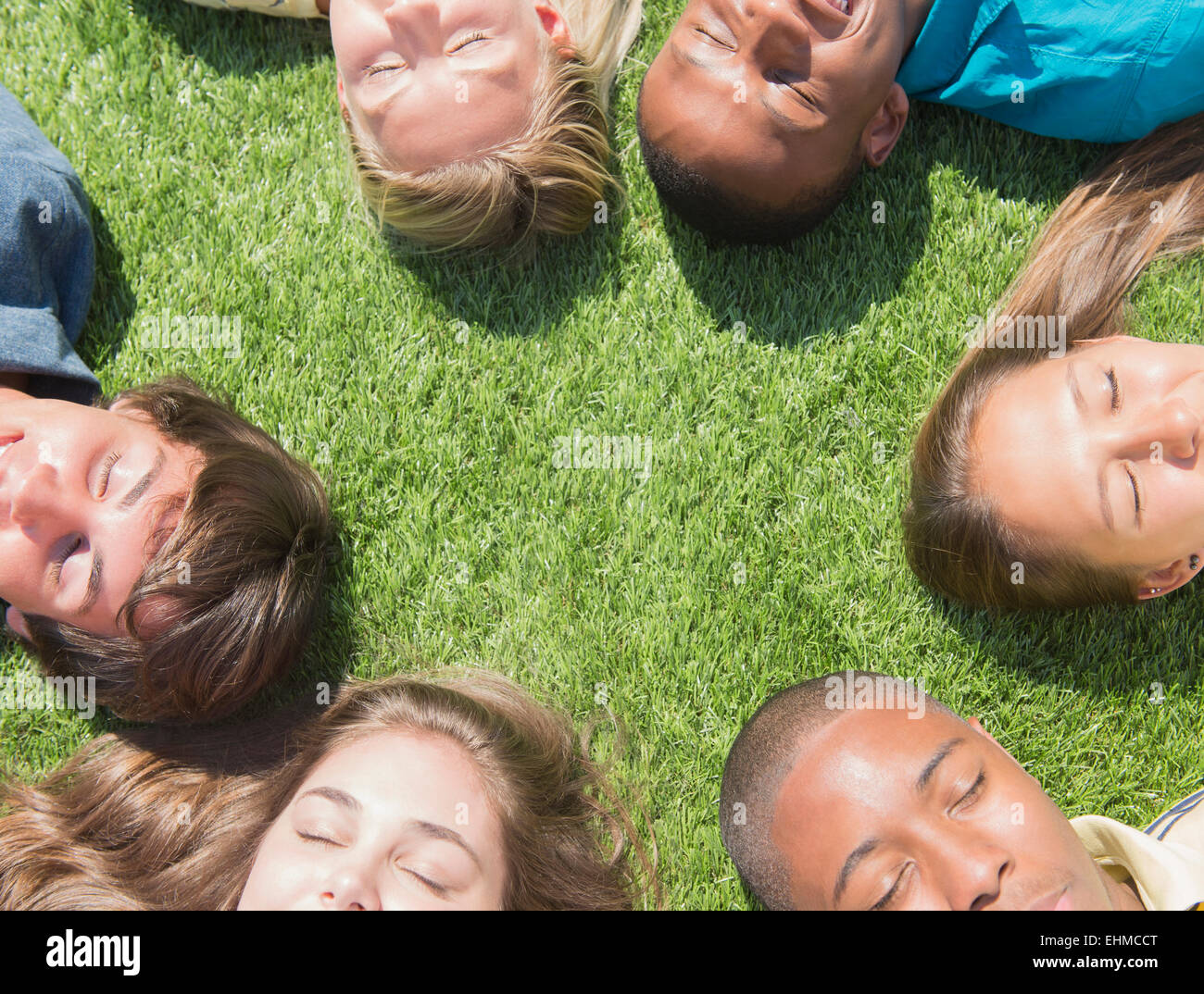 High angle view of teenagers sleeping on grass lawn Stock Photo