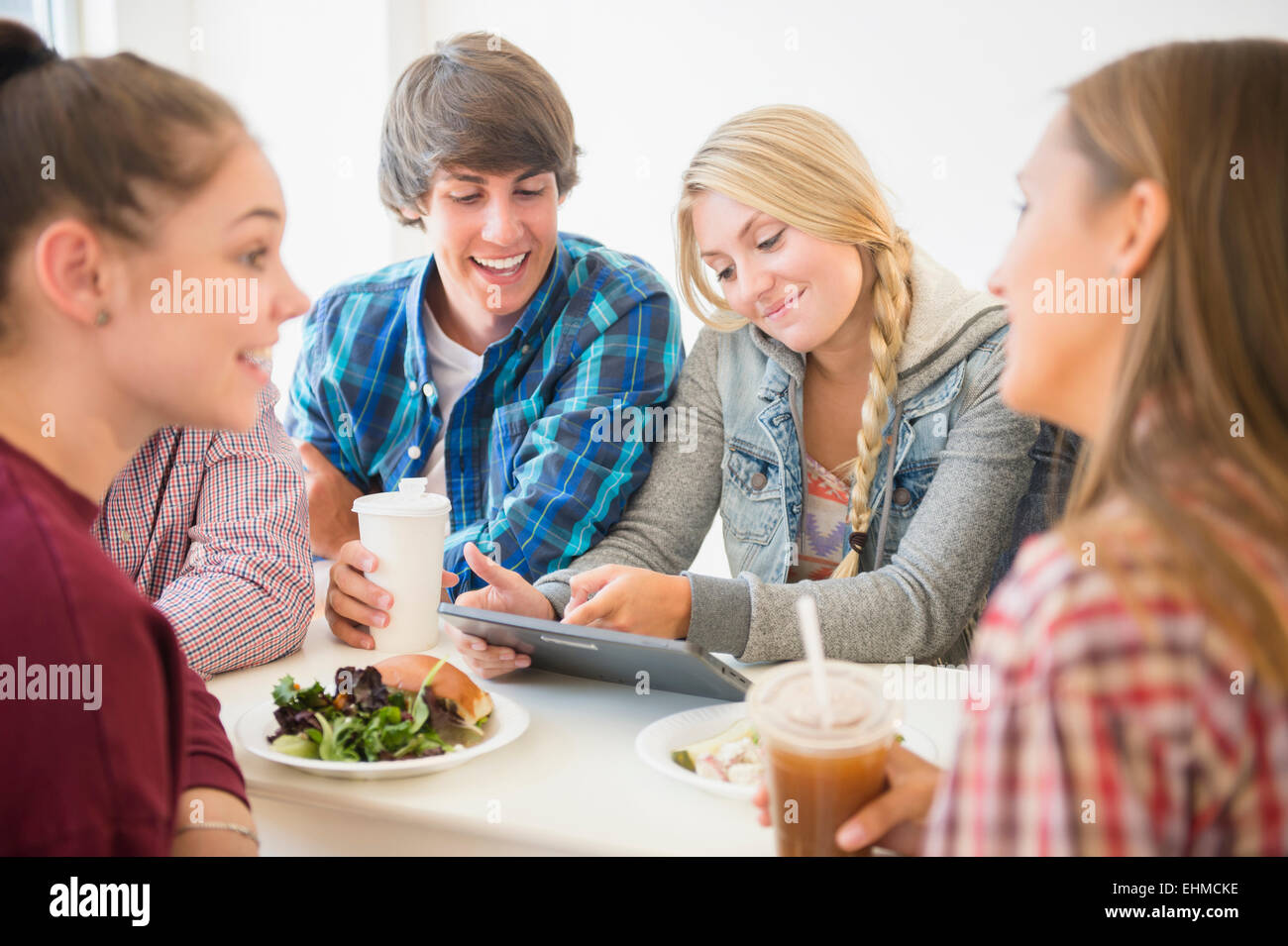 Teenagers using digital tablet at table Stock Photo