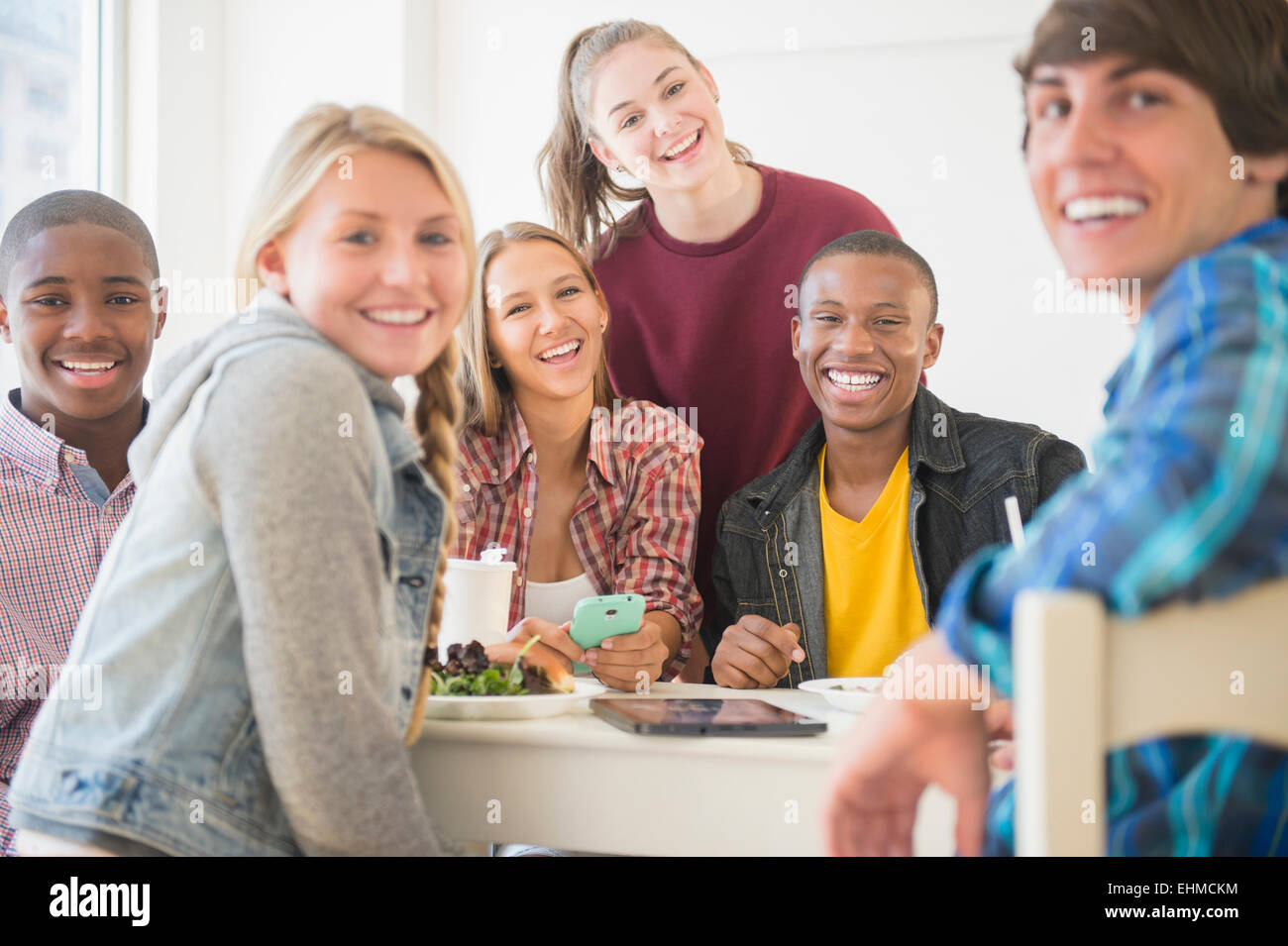 Teenagers smiling at table Stock Photo