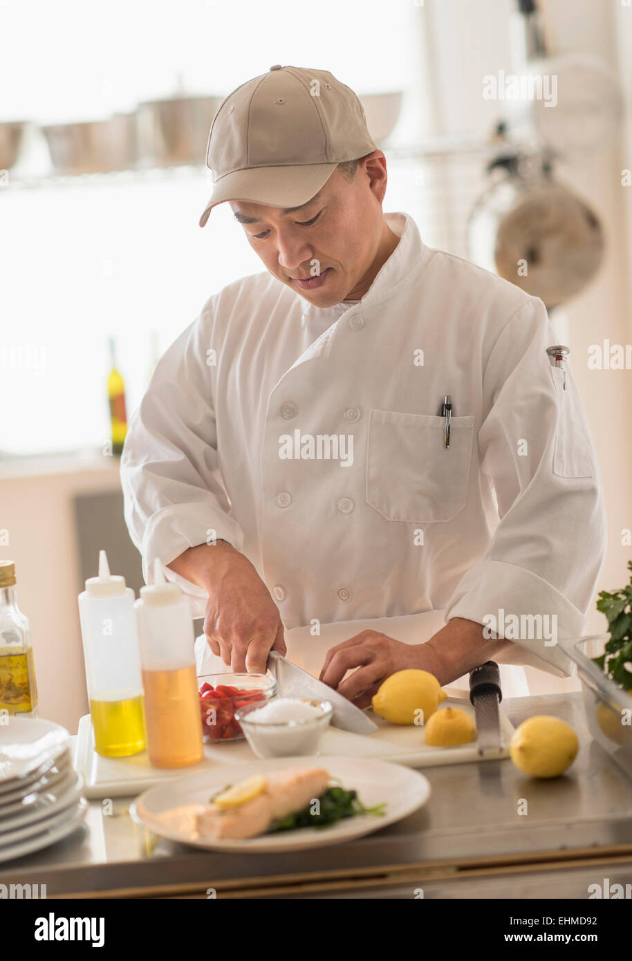 Korean chef slicing food in kitchen Stock Photo