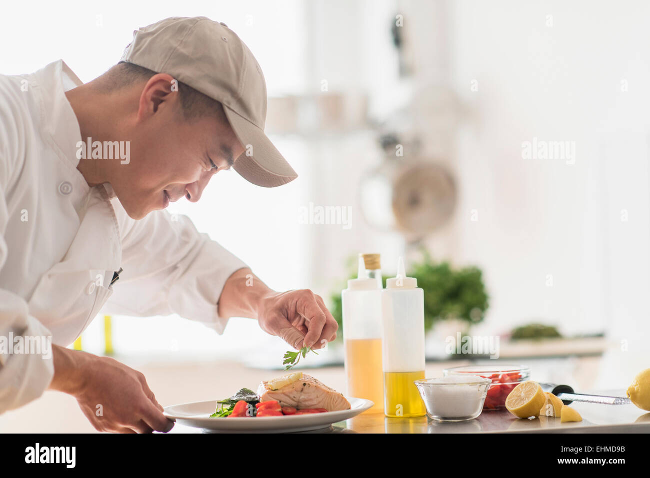 Korean chef preparing meal in kitchen Stock Photo