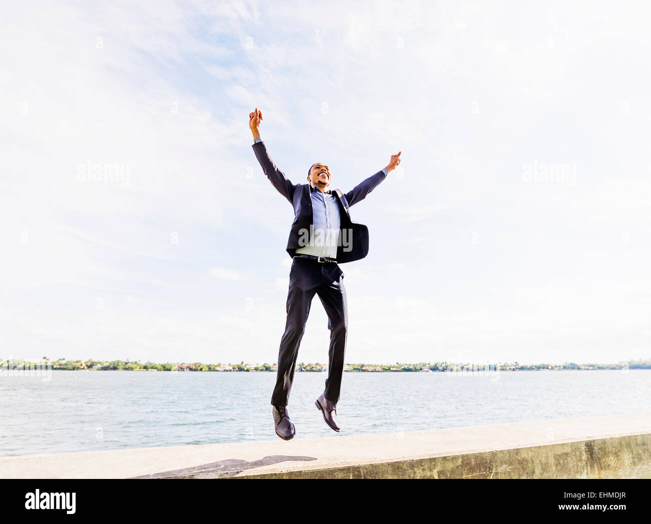 Black businessman jumping for joy outdoors Stock Photo