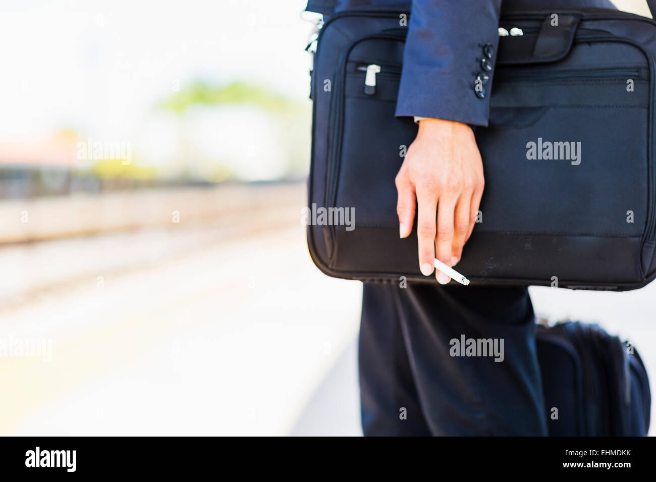 Black businessman holding cigarette outdoors Stock Photo