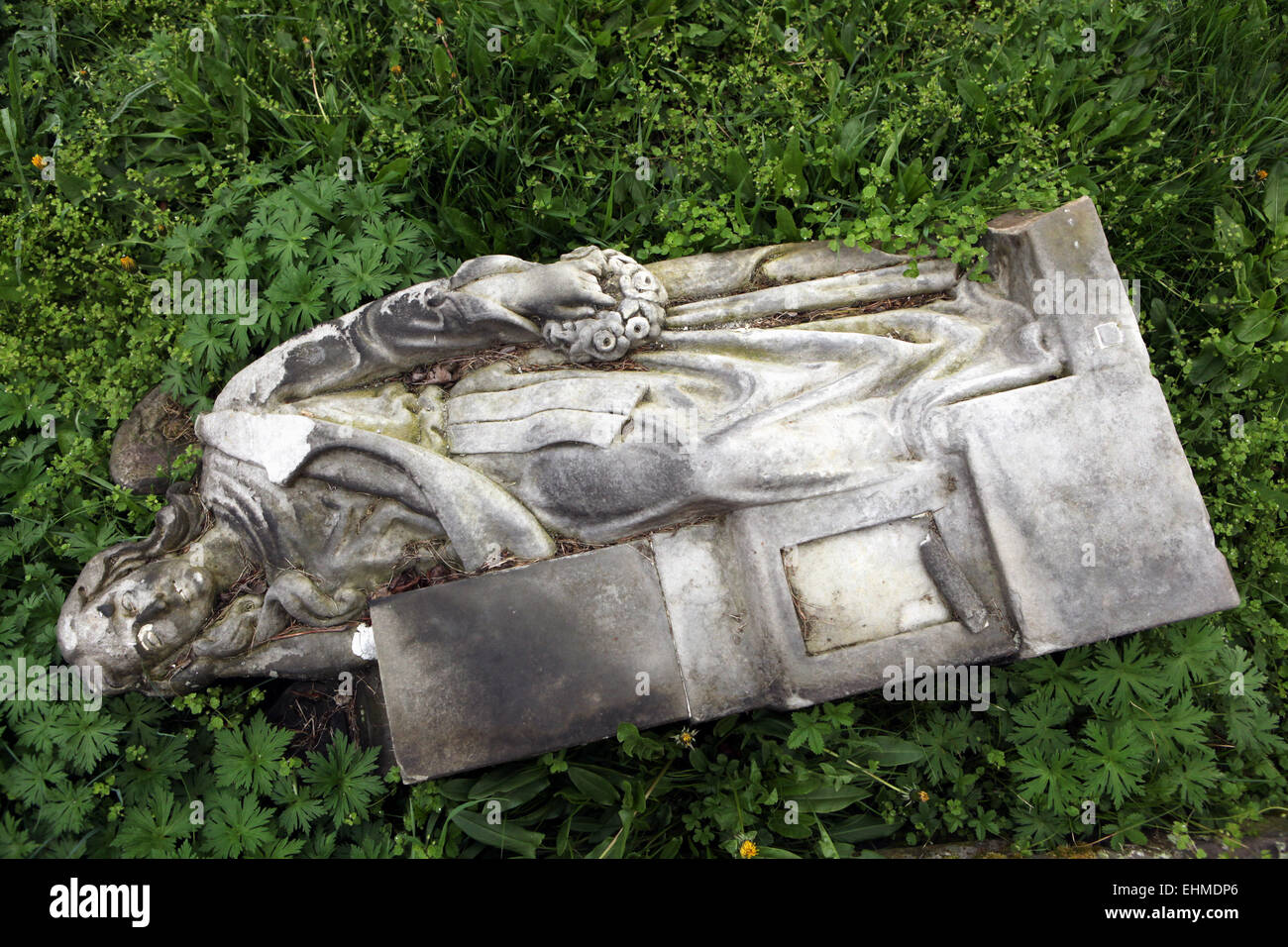 Fallen angel. Destroyed tombstone at an abandoned cemetery in Terezin, Czech Republic. Stock Photo