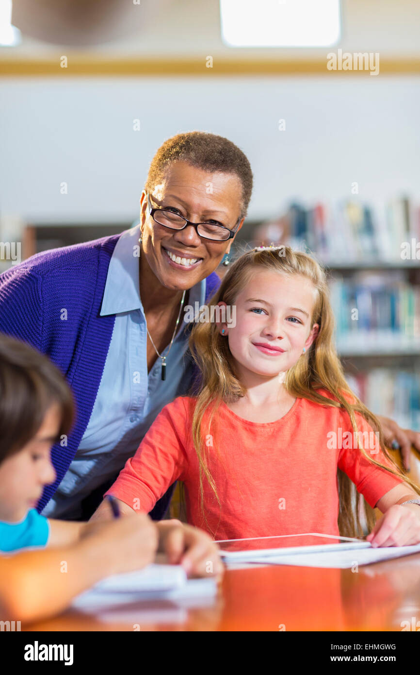 Teacher and student smiling in library Stock Photo - Alamy