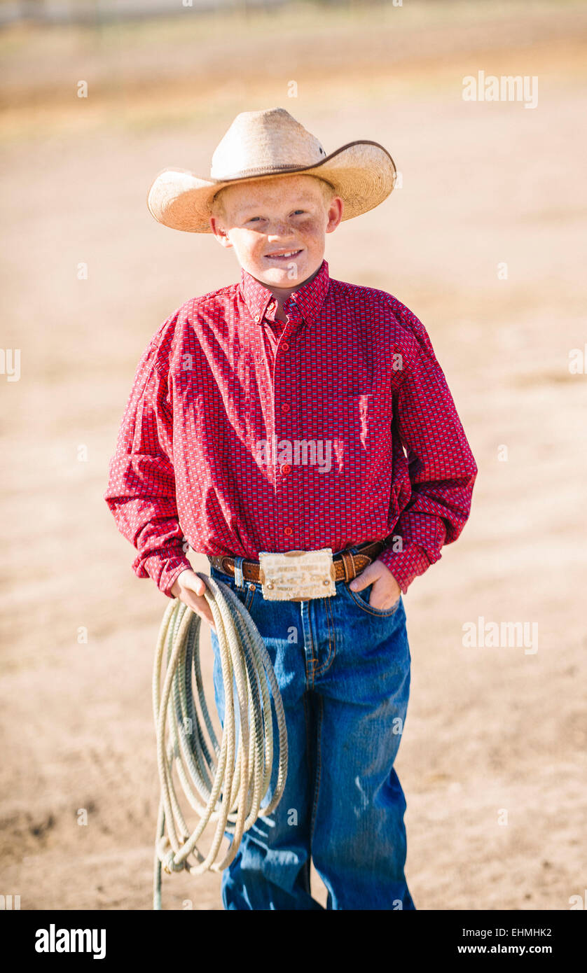 Caucasian boy in cowboy outfit carrying lasso Stock Photo