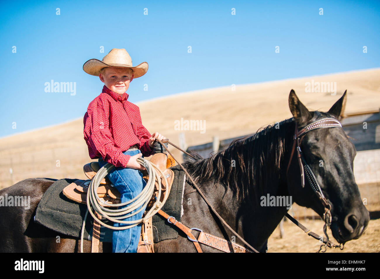 Caucasian boy riding horse on ranch Stock Photo