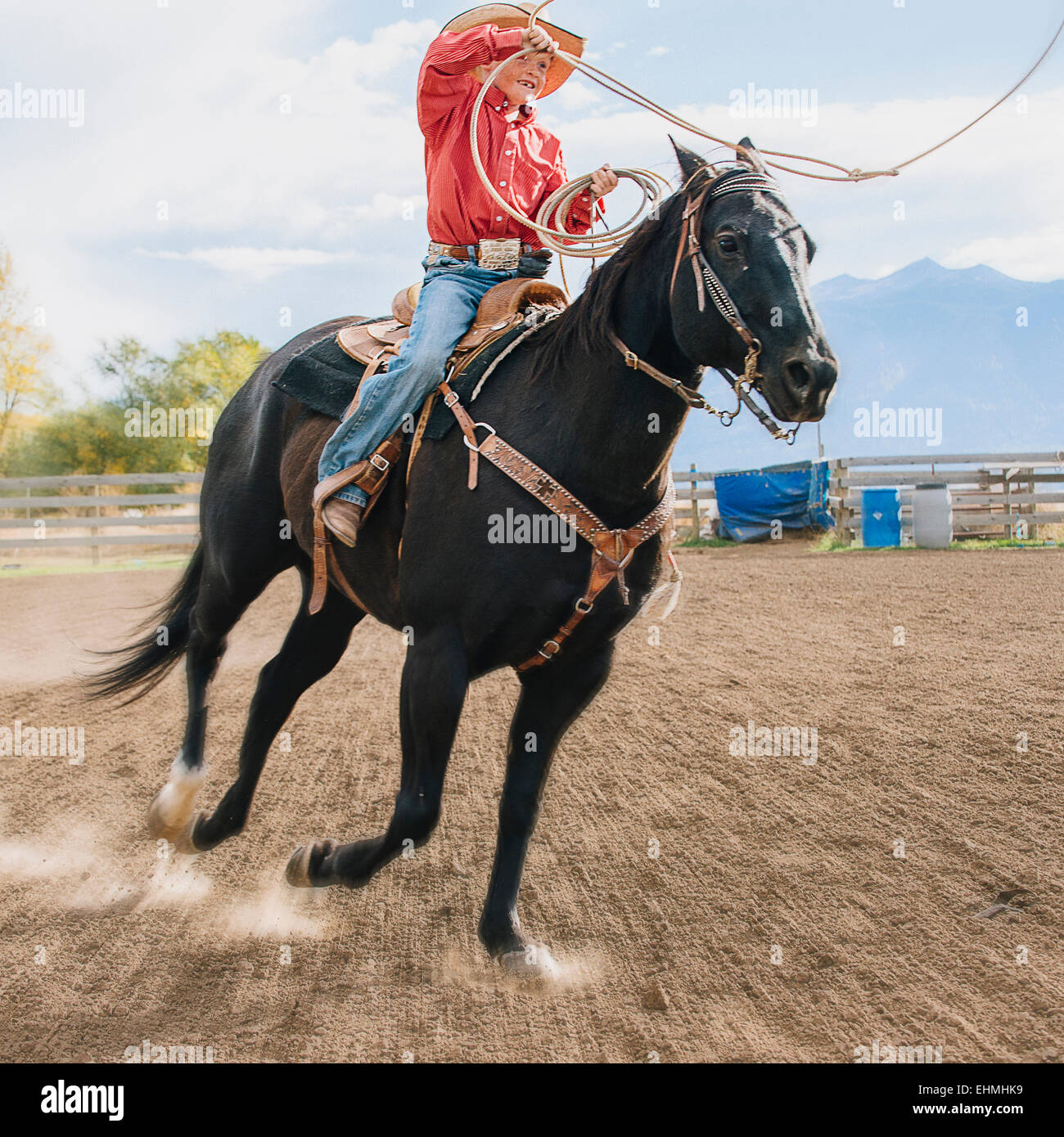 Caucasian boy using lasso on horse at rodeo Stock Photo