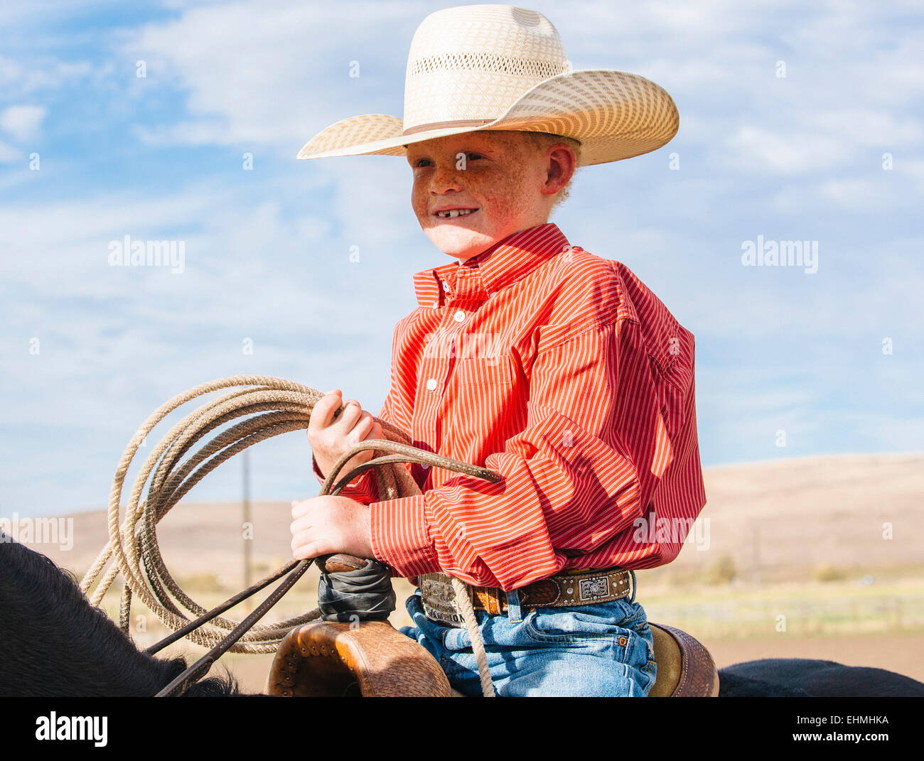 Caucasian boy on horse carrying lasso Stock Photo