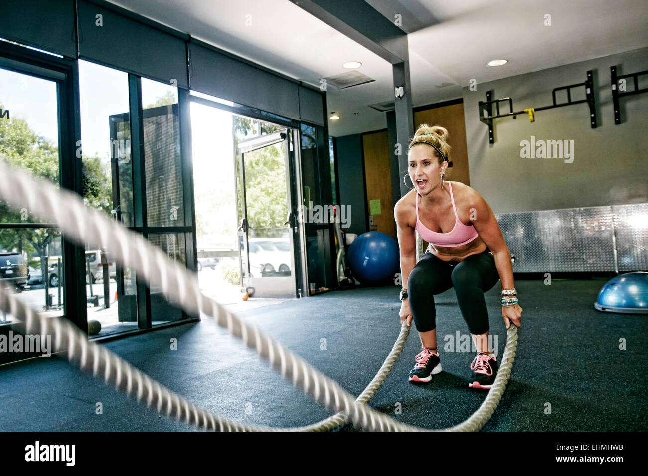 Caucasian woman working out with ropes in gym Stock Photo