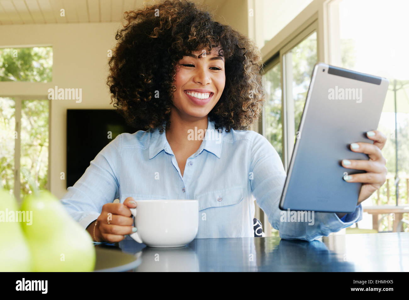 Mixed race businesswoman using digital tablet at table Stock Photo