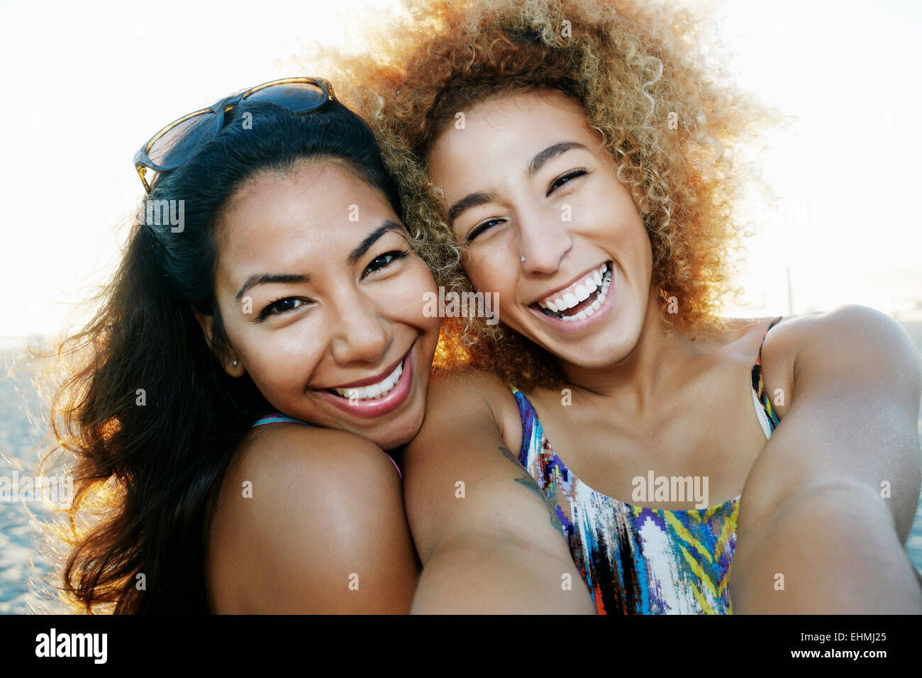 Smiling Hispanic women taking selfie together outdoors Stock Photo
