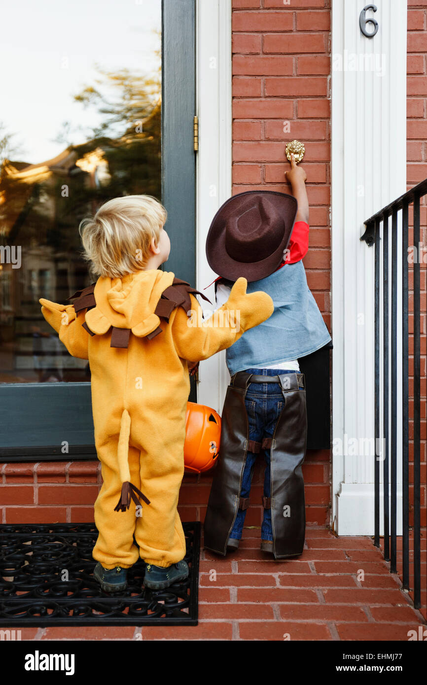 Boys in costumes trick or treating together on Halloween Stock Photo