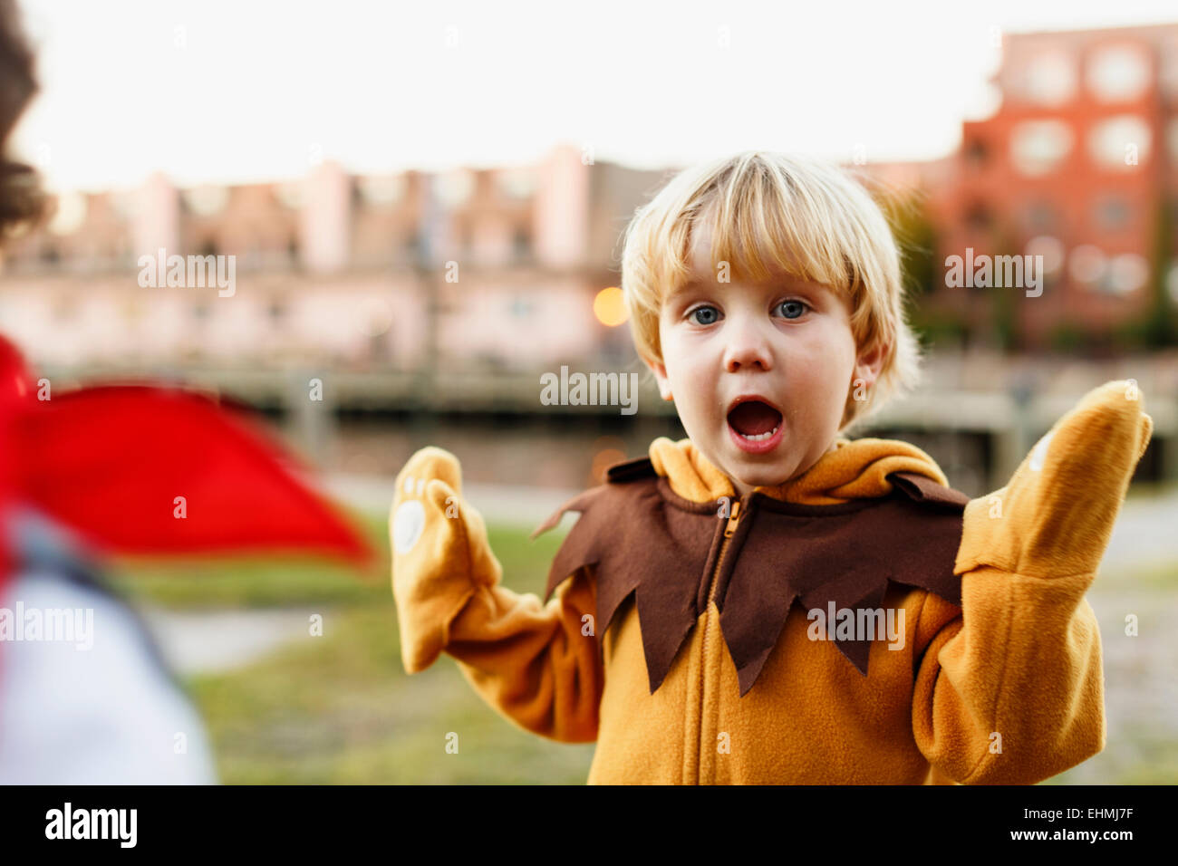 Caucasian boy playing in lion costume outdoors Stock Photo
