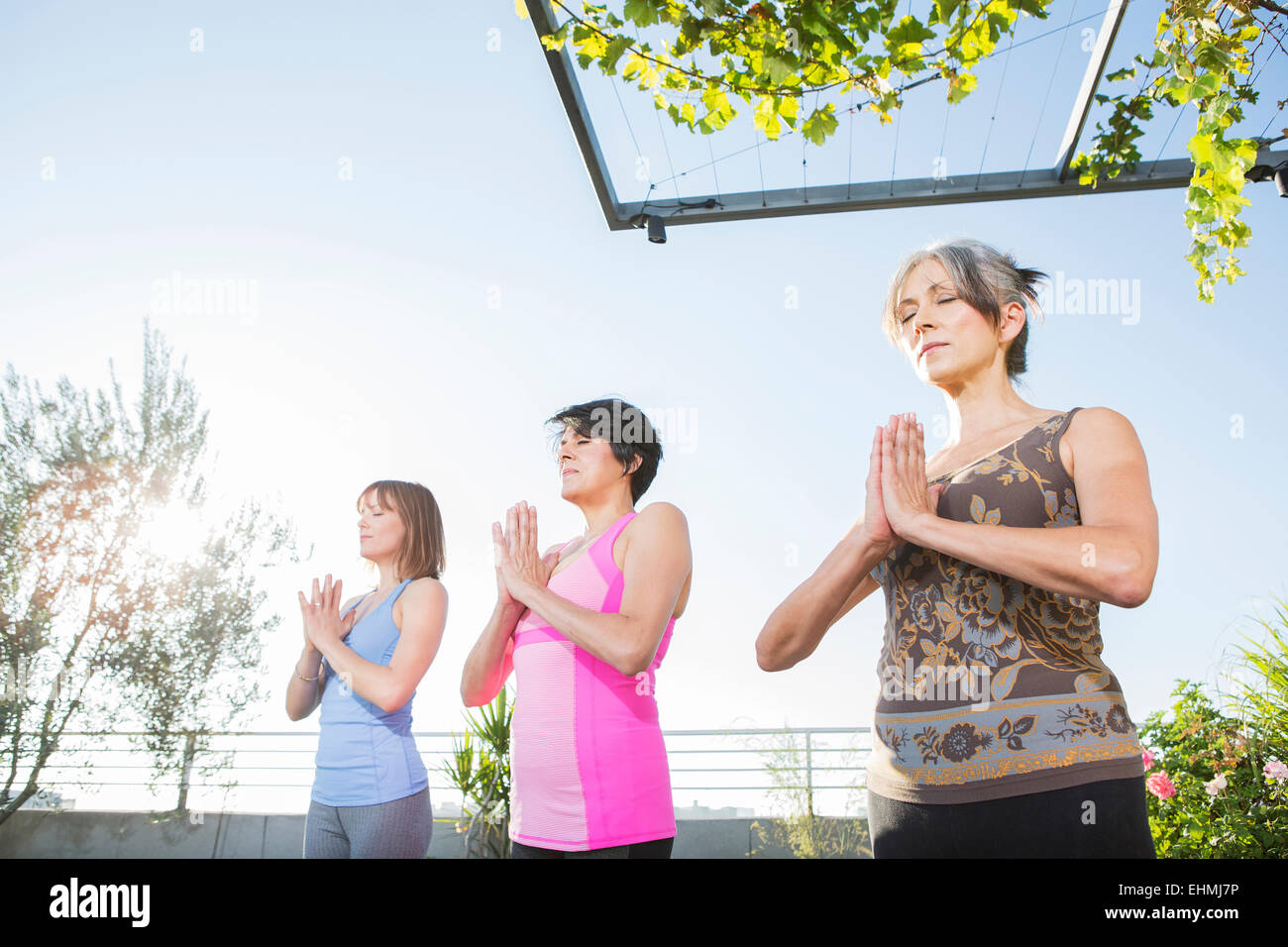 Women practicing yoga together on urban rooftop Stock Photo