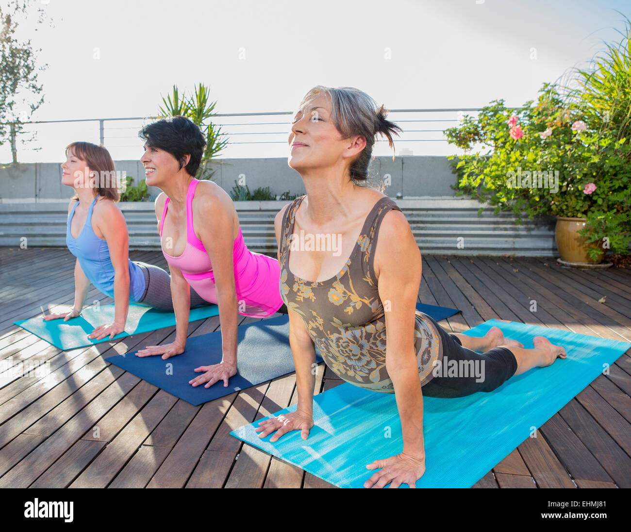 Women practicing yoga together on urban rooftop Stock Photo